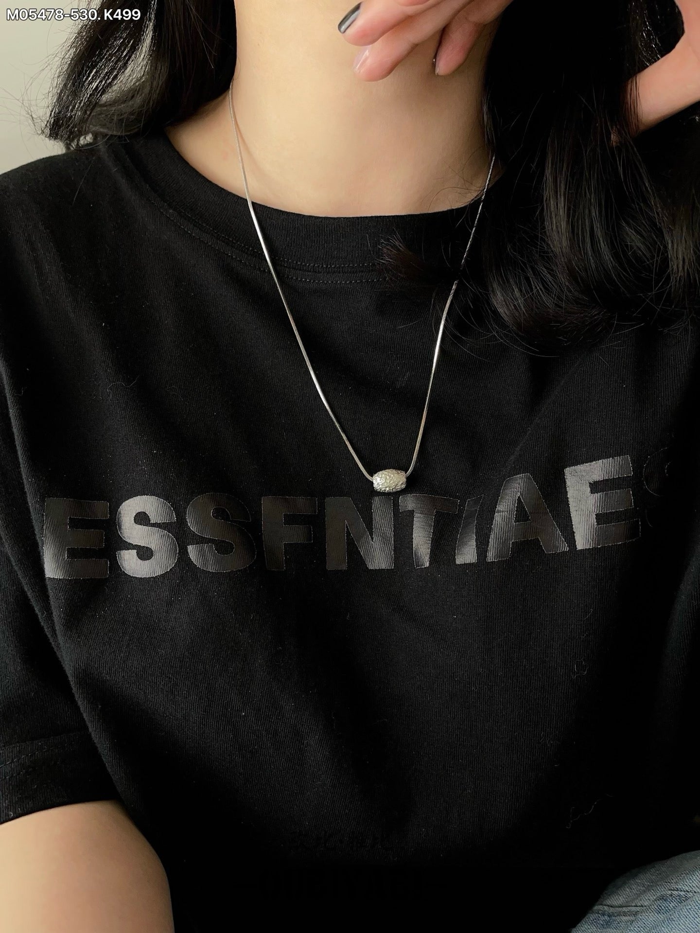 Two-tone metal necklace with silver and gold chains and a carved pendant.