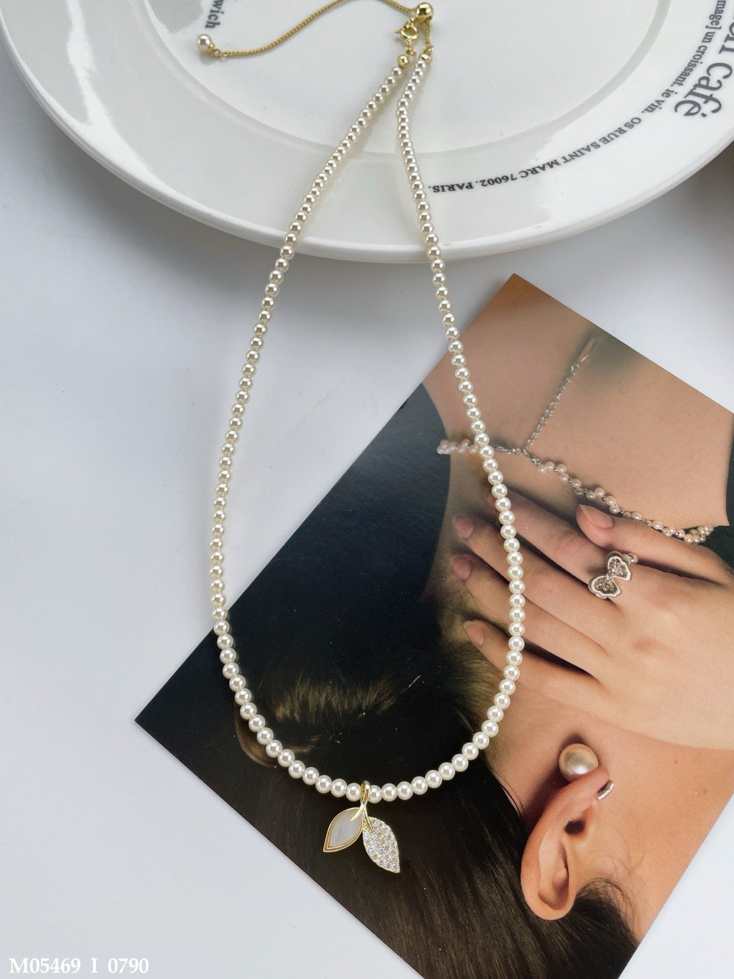 Classic pearl necklace with a leaf pendant and zircon stone details.