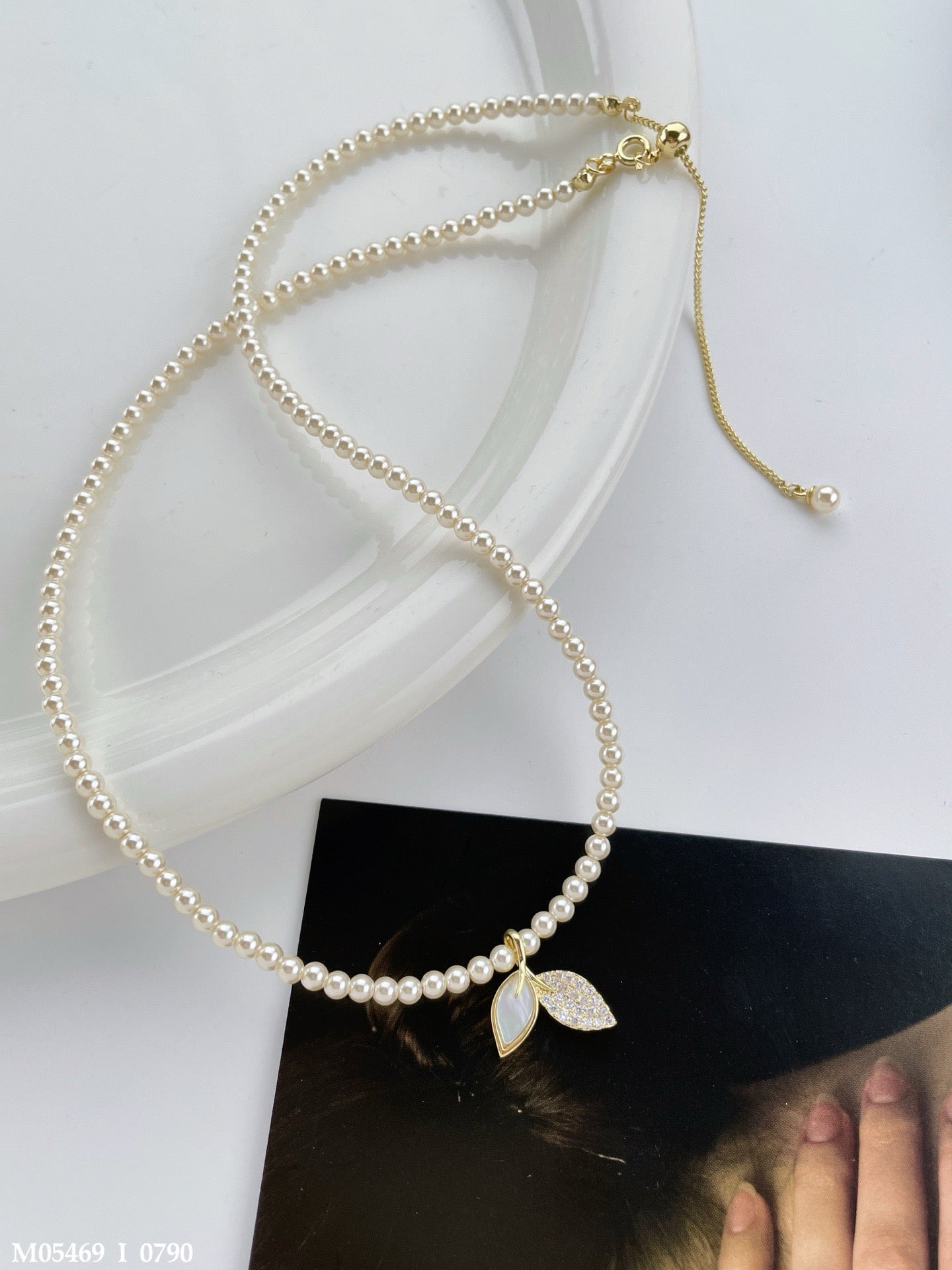Classic pearl necklace with a leaf pendant and zircon stone details.
