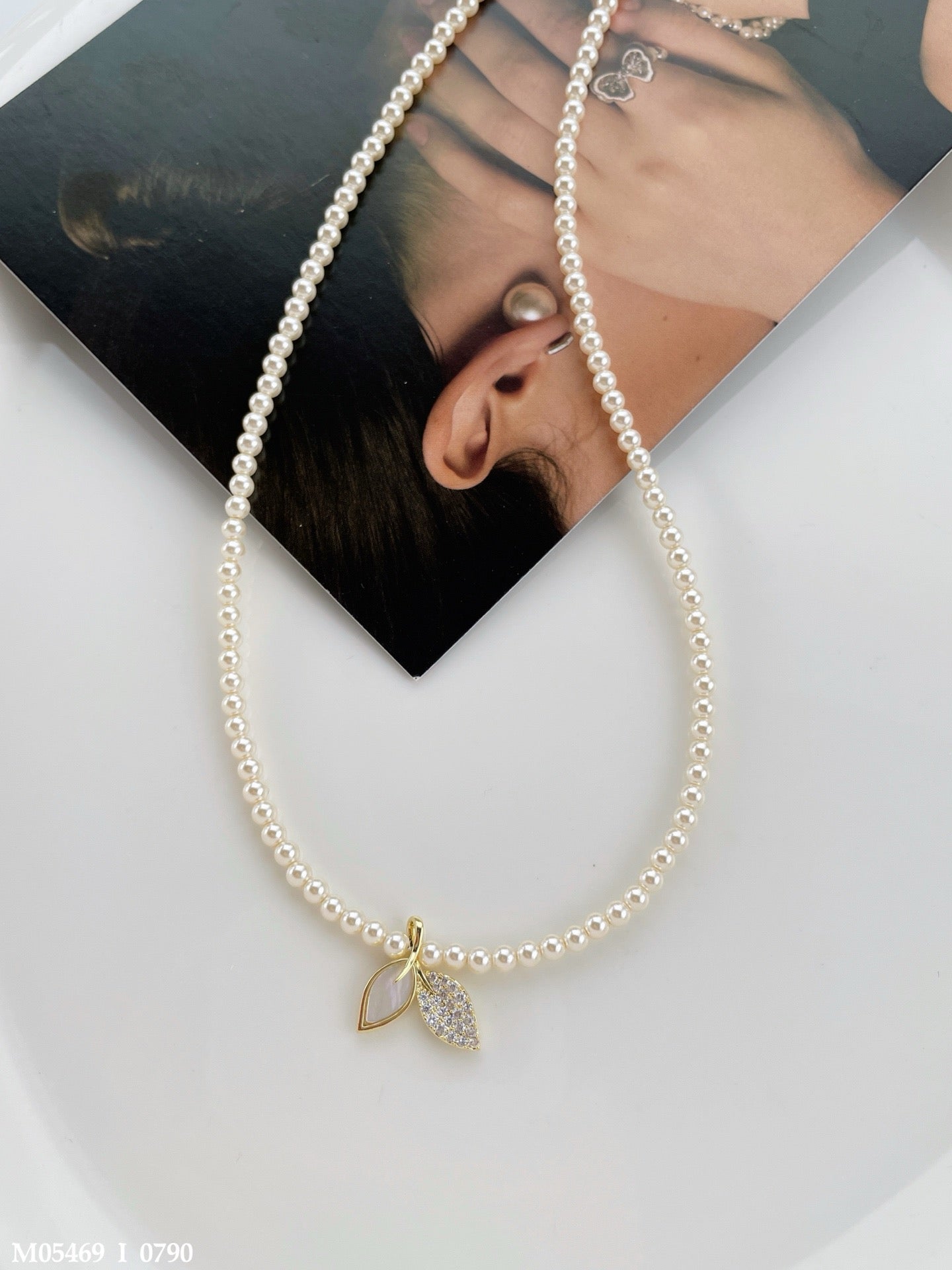 Classic pearl necklace with a leaf pendant and zircon stone details.