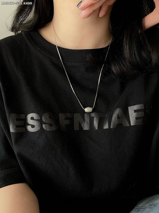 Two-tone metal necklace with silver and gold chains and a carved pendant.
