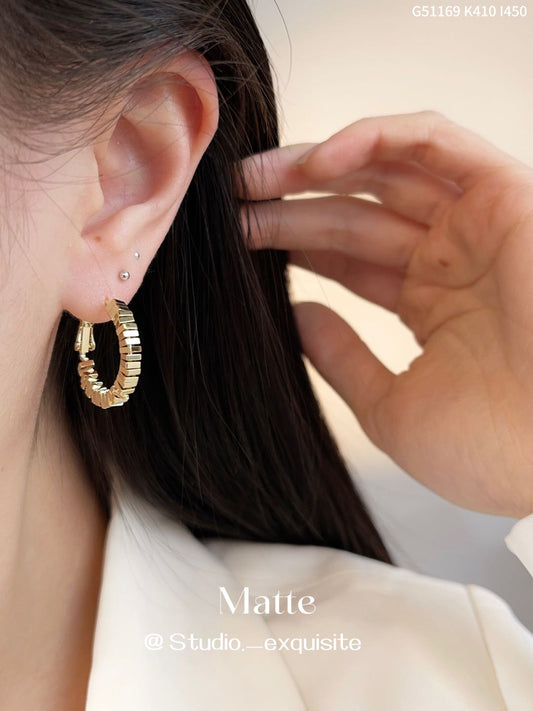Stylish round earrings in gold and silver with geometric detail